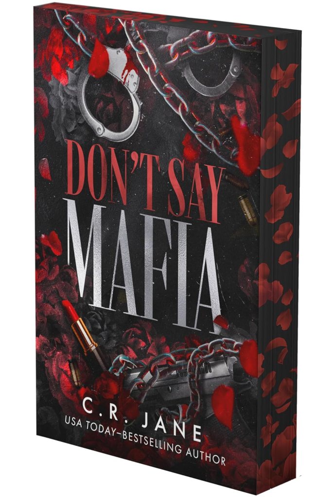 Book cover for 'Don't Say Mafia' by C.R. Jane, featuring a dark background with red roses, blood splatters, handcuffs, and a gun, highlighting a crime theme.